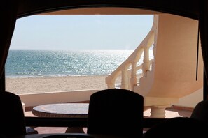 Uitzicht vanuit een kamer met balkon op een strand.