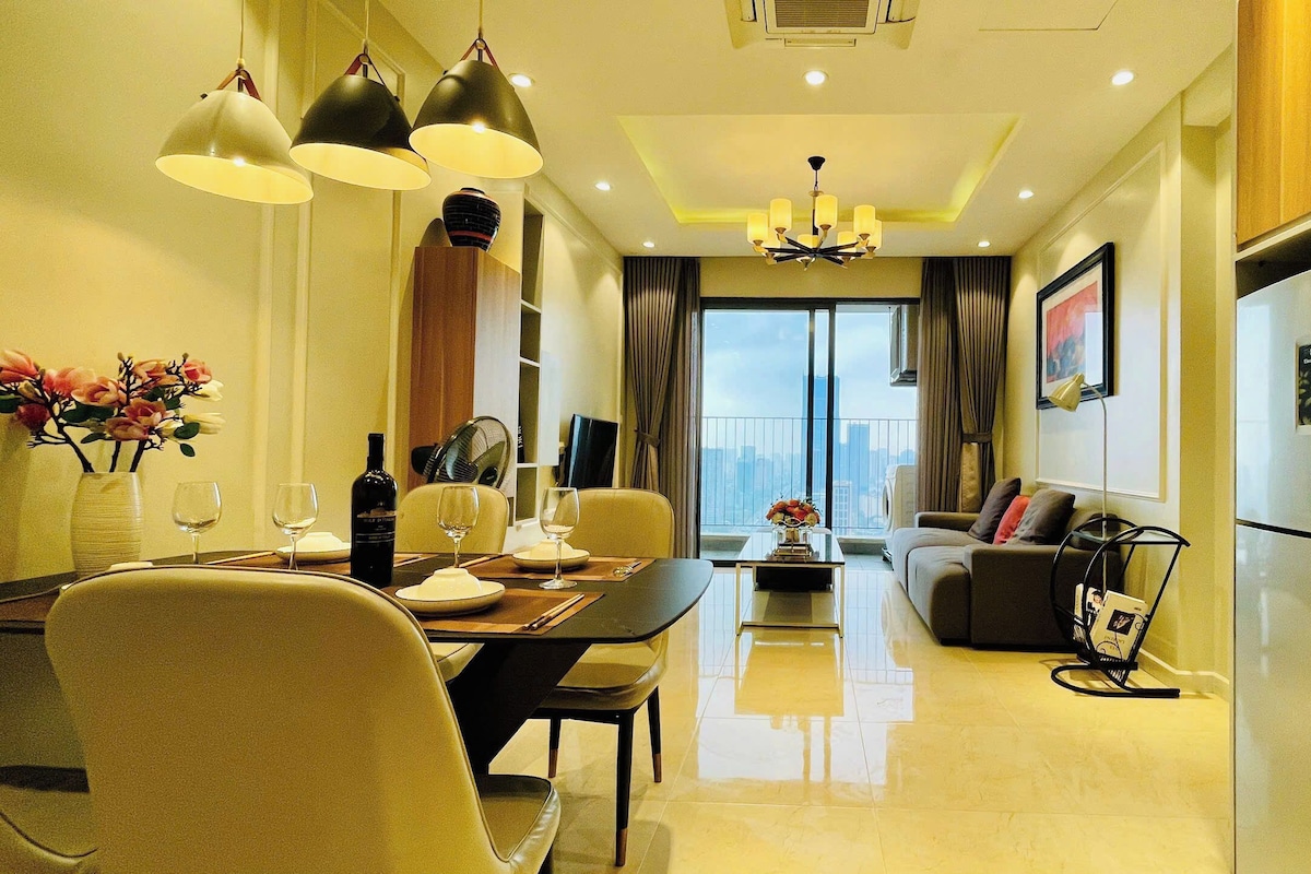 A modern living room with a dining area, a sofa, a coffee table, and a view of the city.