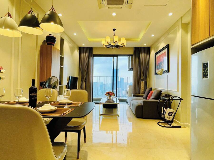 A modern living room with a dining area, a sofa, a coffee table, and a view of the city.