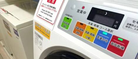 Une vue de face d’un lave-linge doté de nombreux boutons et d’une étiquette en japonais.