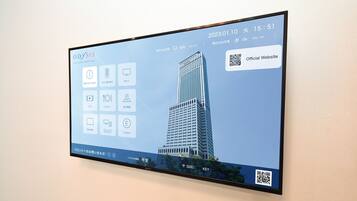 A digital display of the Odyasis Suites Osaka Airport Hotel with a modern building and various hotel amenities icons.