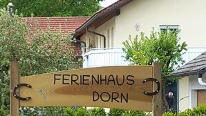 Puinen kyltti, jossa lukee ”Ferienhaus Dorn” ja sen alla ”Zimmer mit DU/WO” (huoneita, joissa on oma kylpyhuone).