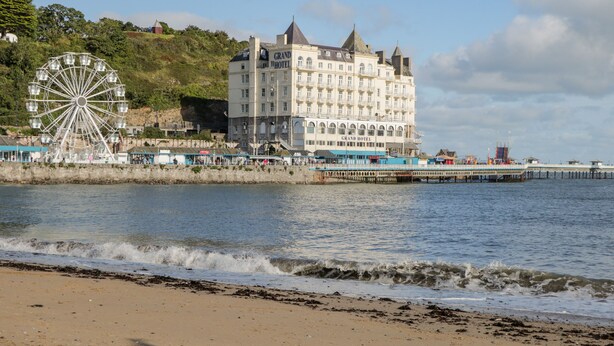 A coastal hotel with a large Ferris wheel and a pier extending into the water. - Dolwen (Betws-Y-Coed)
