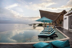 Una piscina al aire libre, sillones reclinables de piscina