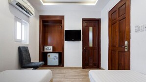 A small, well-lit room with two beds, a television, a refrigerator, and a wardrobe. - MAY'S HOTEL-BEN THANH MARKET (Ho Chi Minh City)