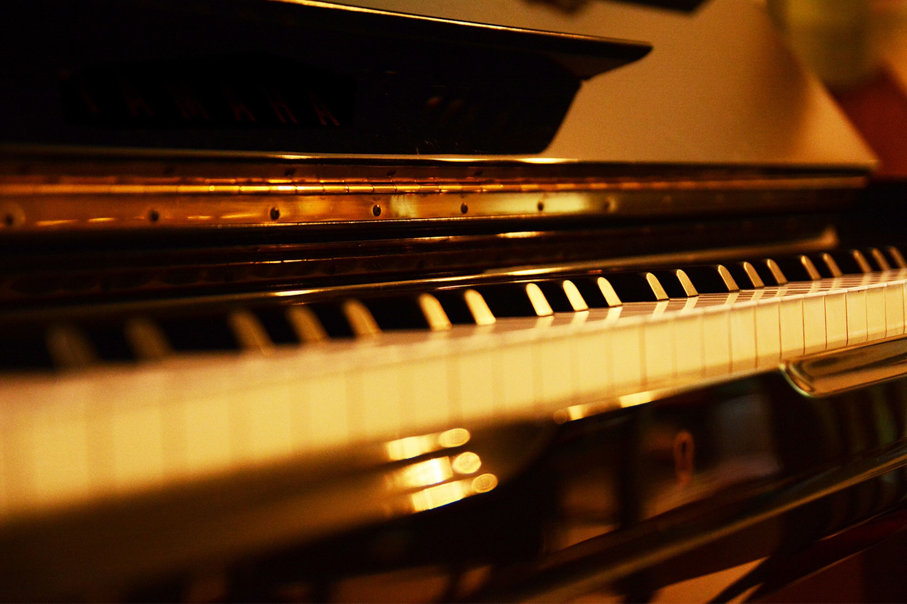 A close-up of a piano keyboard with a reflective surface.