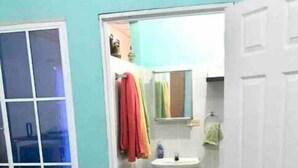 A bathroom with a sink, mirror, and towel rack.
