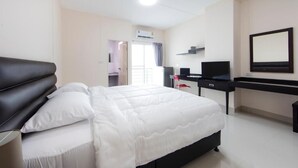 Ein Hotelzimmer mit Bett, Schreibtisch, Fernseher und einem großen Spiegel.