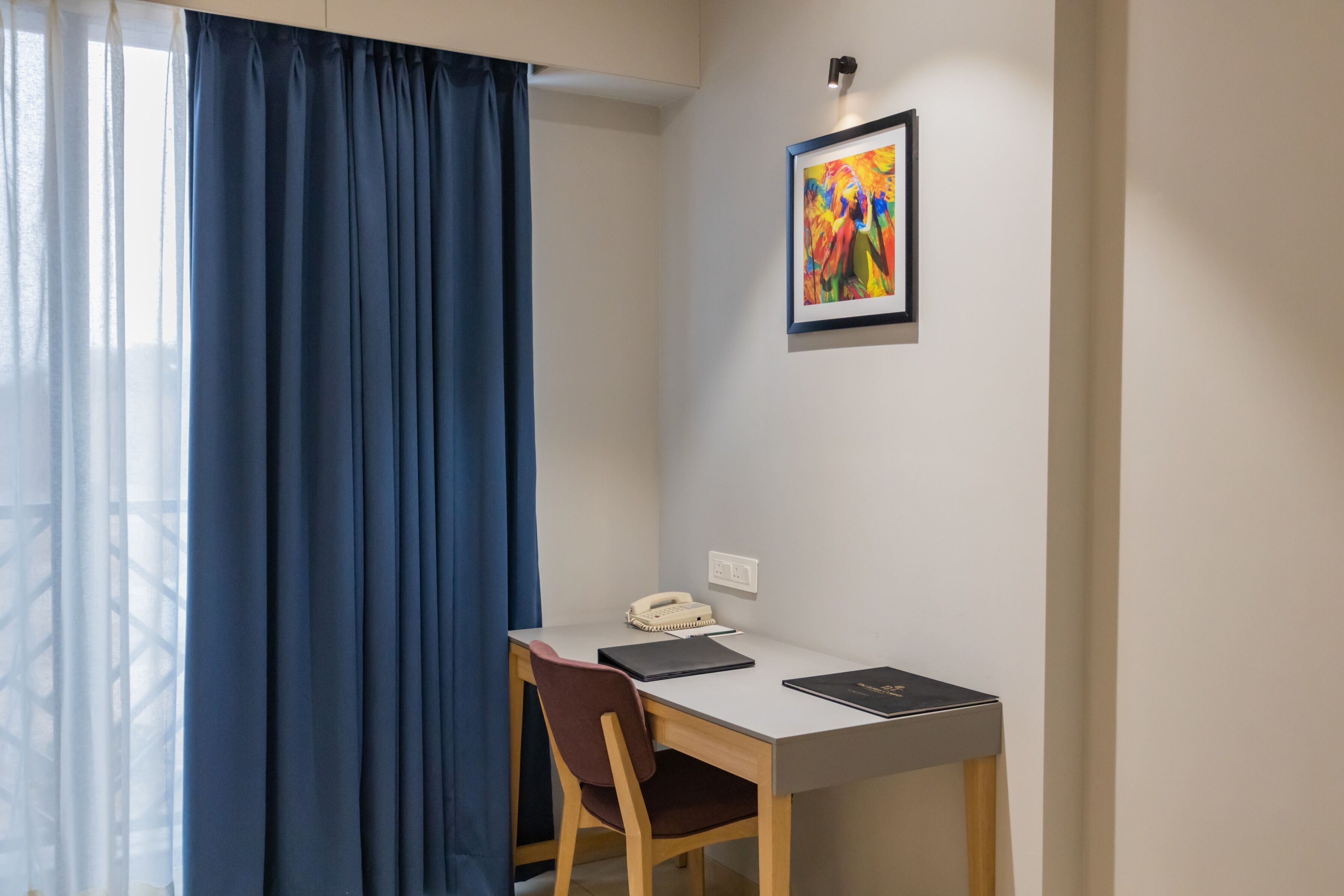 A room with a desk, chair, and a telephone.