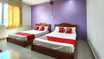 A room with two beds, each with a wooden frame and red and white bedding.