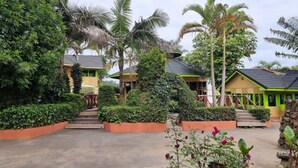 Een resort met meerdere gebouwen in bungalowstijl, omgeven door weelderige begroeiing en palmbomen.