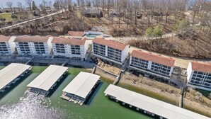A large, modern hotel with multiple buildings and a dock area. - Lighthouse Retreat – Pool, Swim Dock and More! (Lake Ozark)