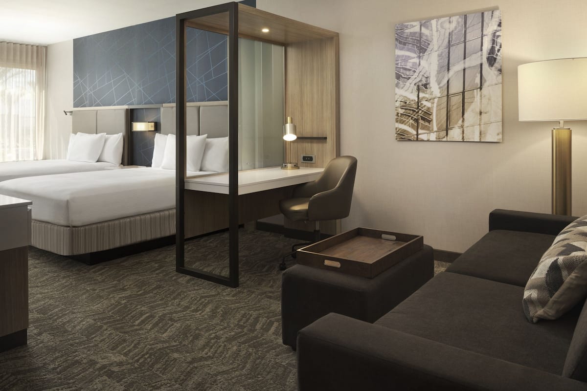Une chambre d’hôtel avec un lit, un bureau, une chaise et un canapé.