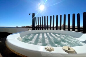 A hot tub with water jets, a sun, and a clear sky.