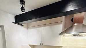 A compact kitchen with white cabinets, a wooden countertop, a stainless steel sink, and a built-in oven. - Charming apartment in the heart of Nieukerk. (Kerken)