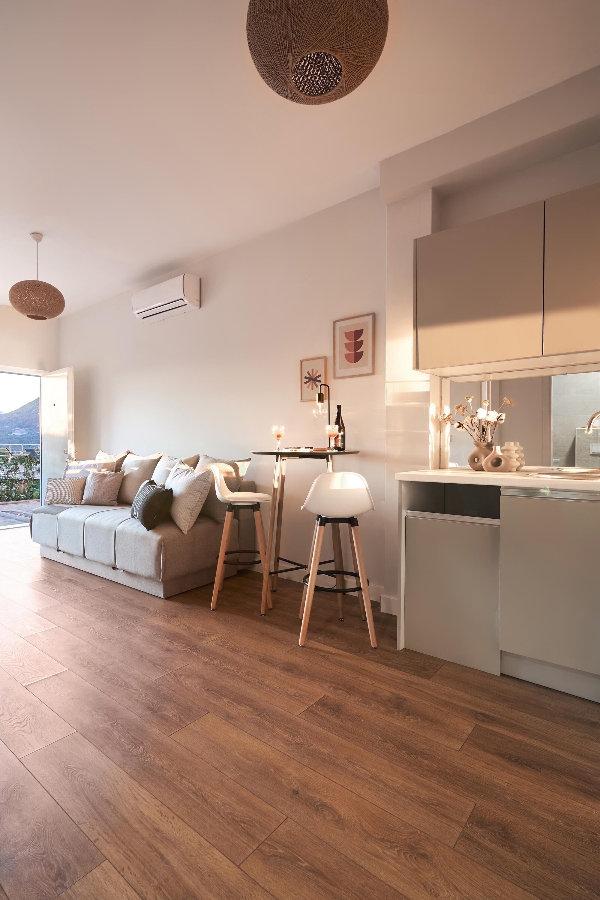 A modern living room with a sofa, a dining area, and a kitchen.