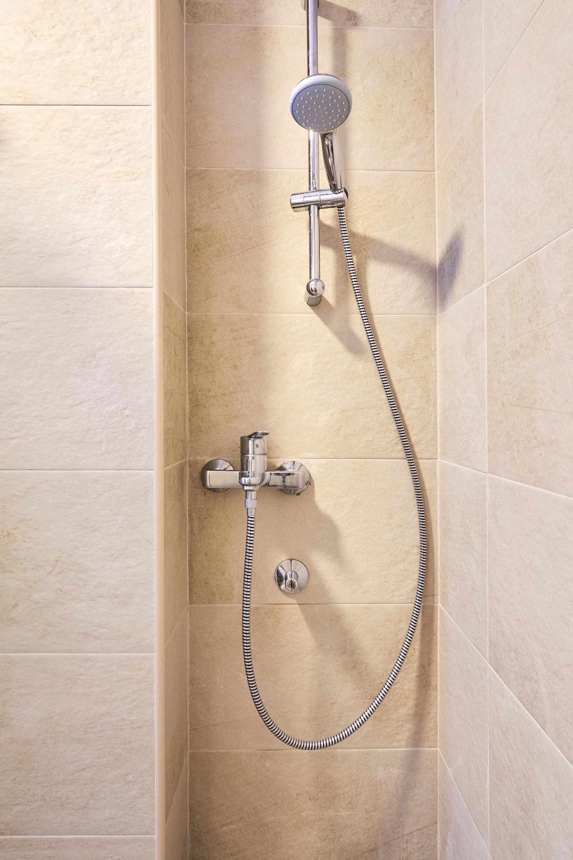 A shower with a handheld showerhead and a flexible hose.