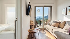A modern living room with a sofa, a small table, and a TV mounted on the wall. -  Casa Collection (Kotor)