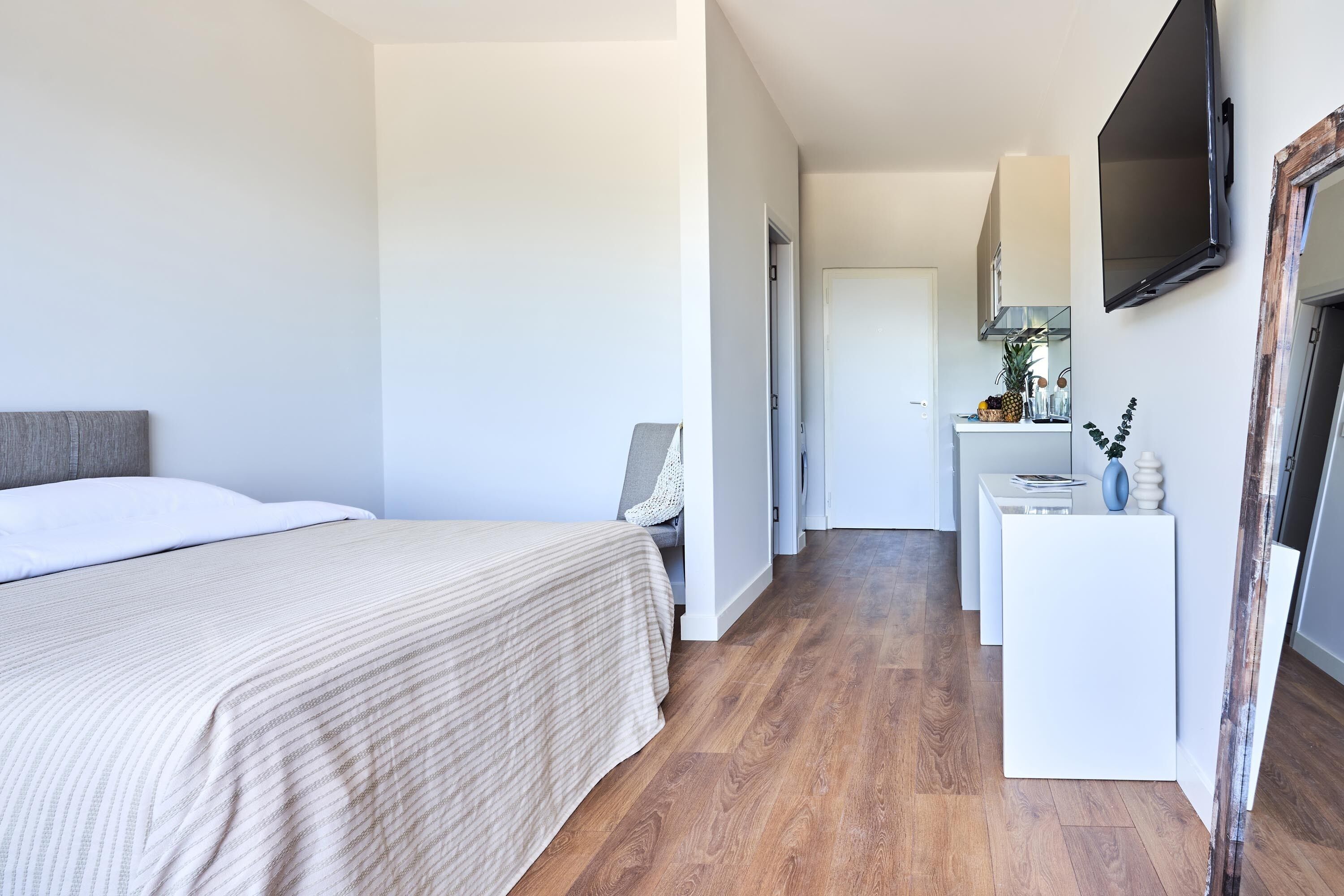 Una habitación de hotel con una cama, un escritorio y un televisor.