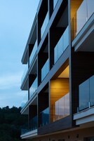 Un edificio moderno de varios pisos con ventanas amplias y balcones.