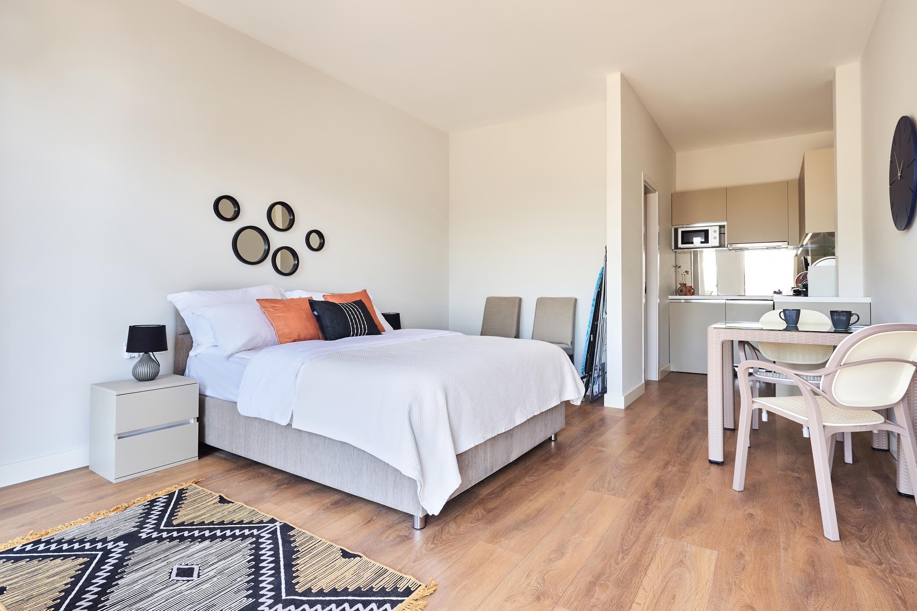 A modern bedroom with a bed, bedside tables, a desk, and a chair.