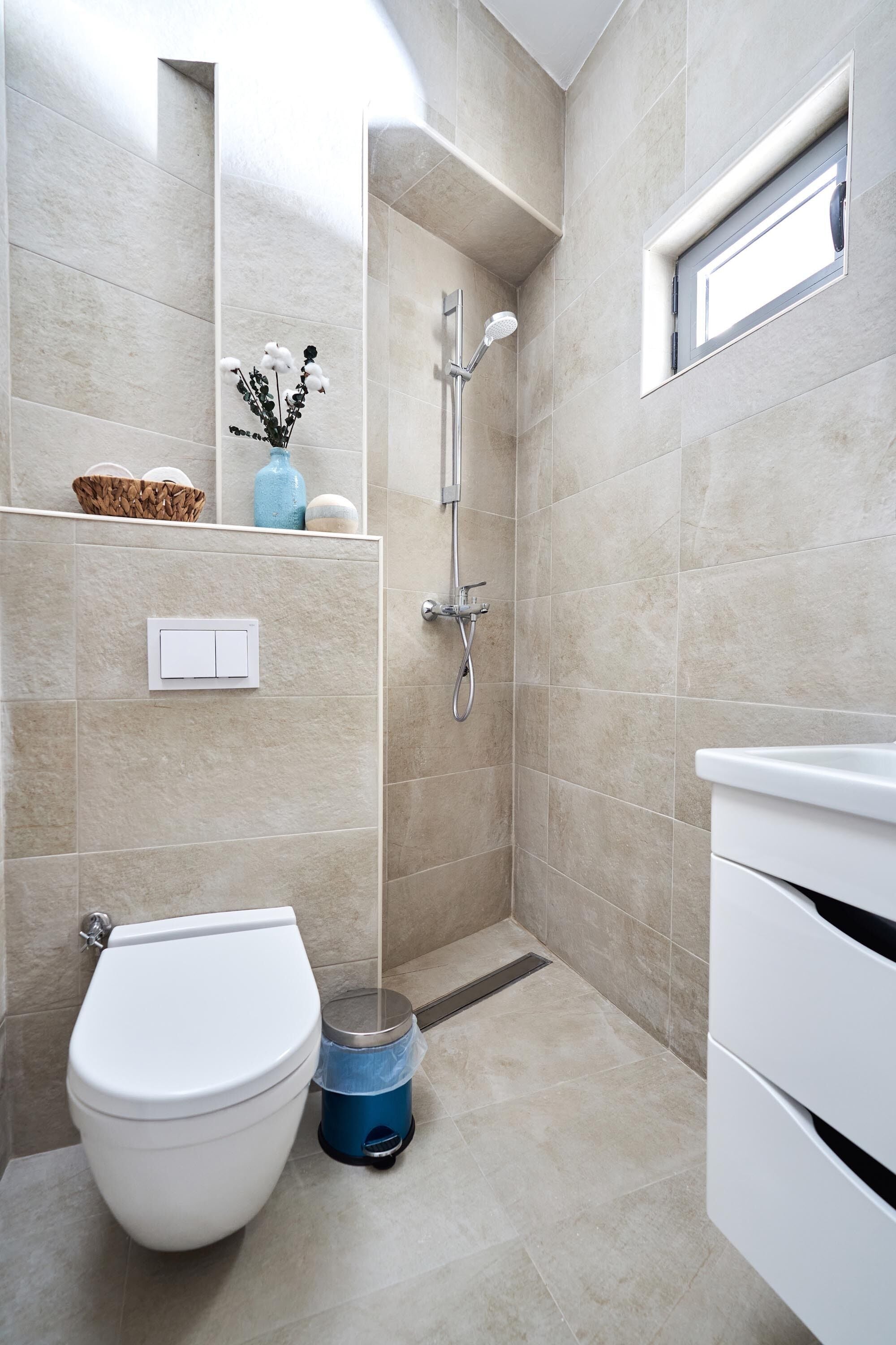 A modern bathroom with a toilet, bidet, and shower.