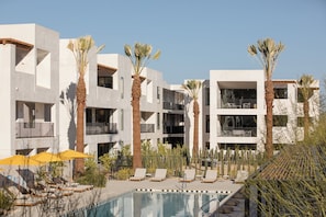 A modern hotel with a pool area, palm trees, and lounge chairs. - Drift Palm Springs (PALM SPRINGS)