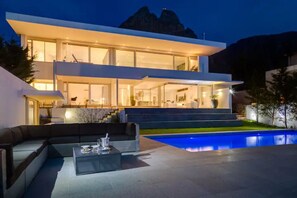 A modern two-story house with a swimming pool, large windows, and a staircase leading to the upper floor. - Villa Maxima - Ultra Stylish, Heated Pool & Sea View (Cape Town)