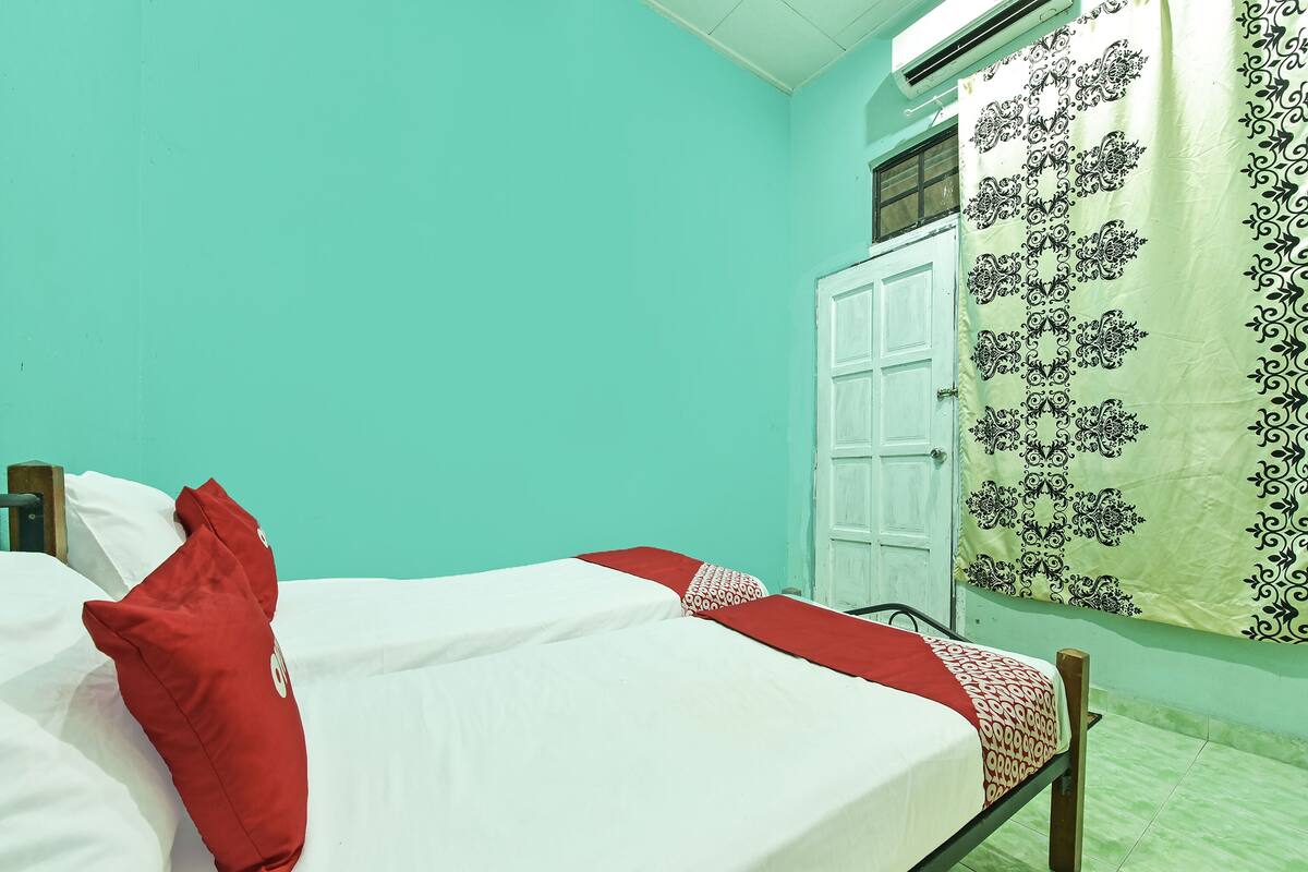 A room with a bed, a wardrobe, and a curtain.