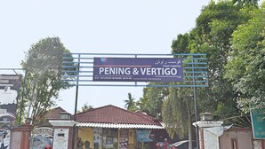 Señal del hotel PENING & VERTIGO con una entrada despejada y un camino de acceso con portón.