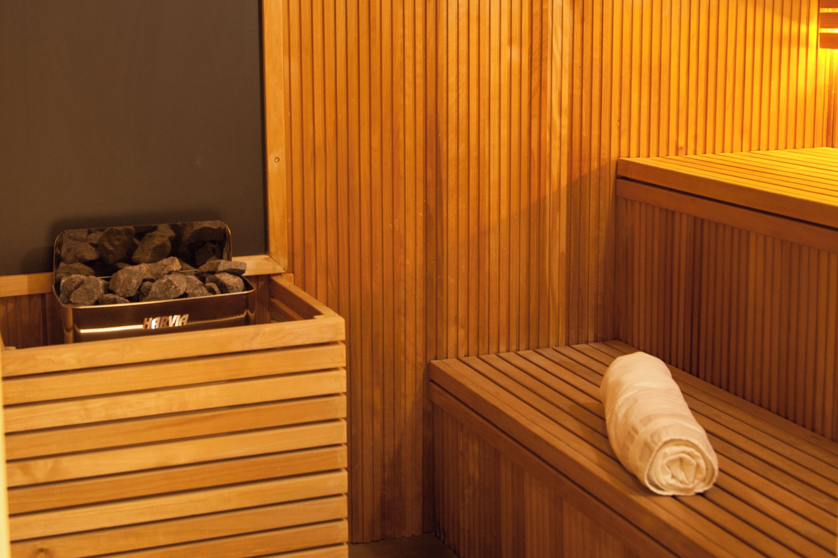 Una sauna de madera con bancos y un banco con una toalla.