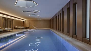 Una piscina techada, sillones reclinables de piscina