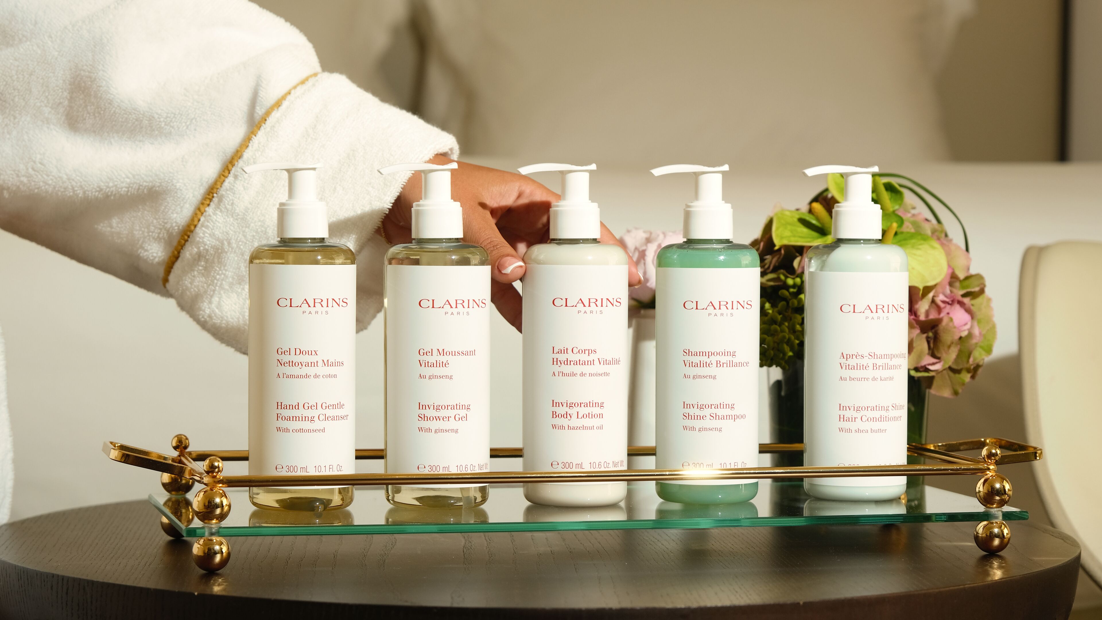A tray with six bottles of Clarins Paris skincare products.