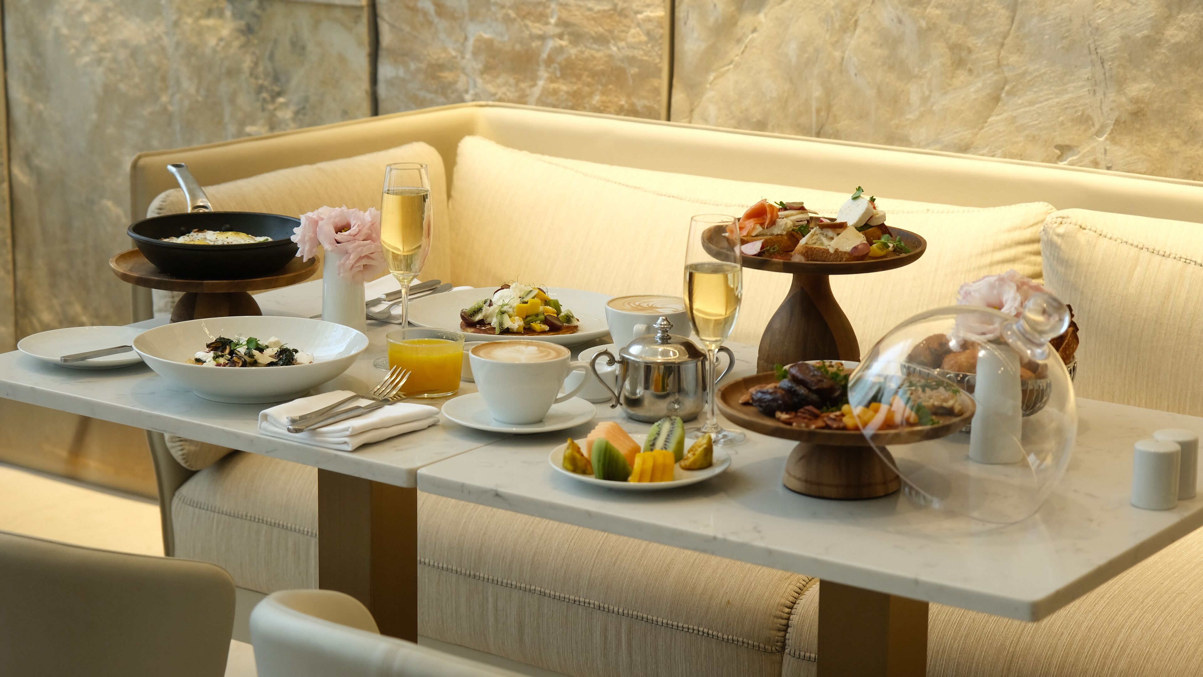 A dining table set with various dishes, a coffee cup, a glass of juice, and a teapot.