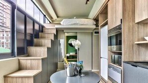 A compact kitchen with a dining area, built-in appliances, and a view through a window. - The Harri 209 (Cape Town)