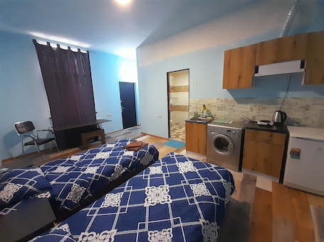 Economy Studio | Down comforters, desk, laptop workspace, iron/ironing board