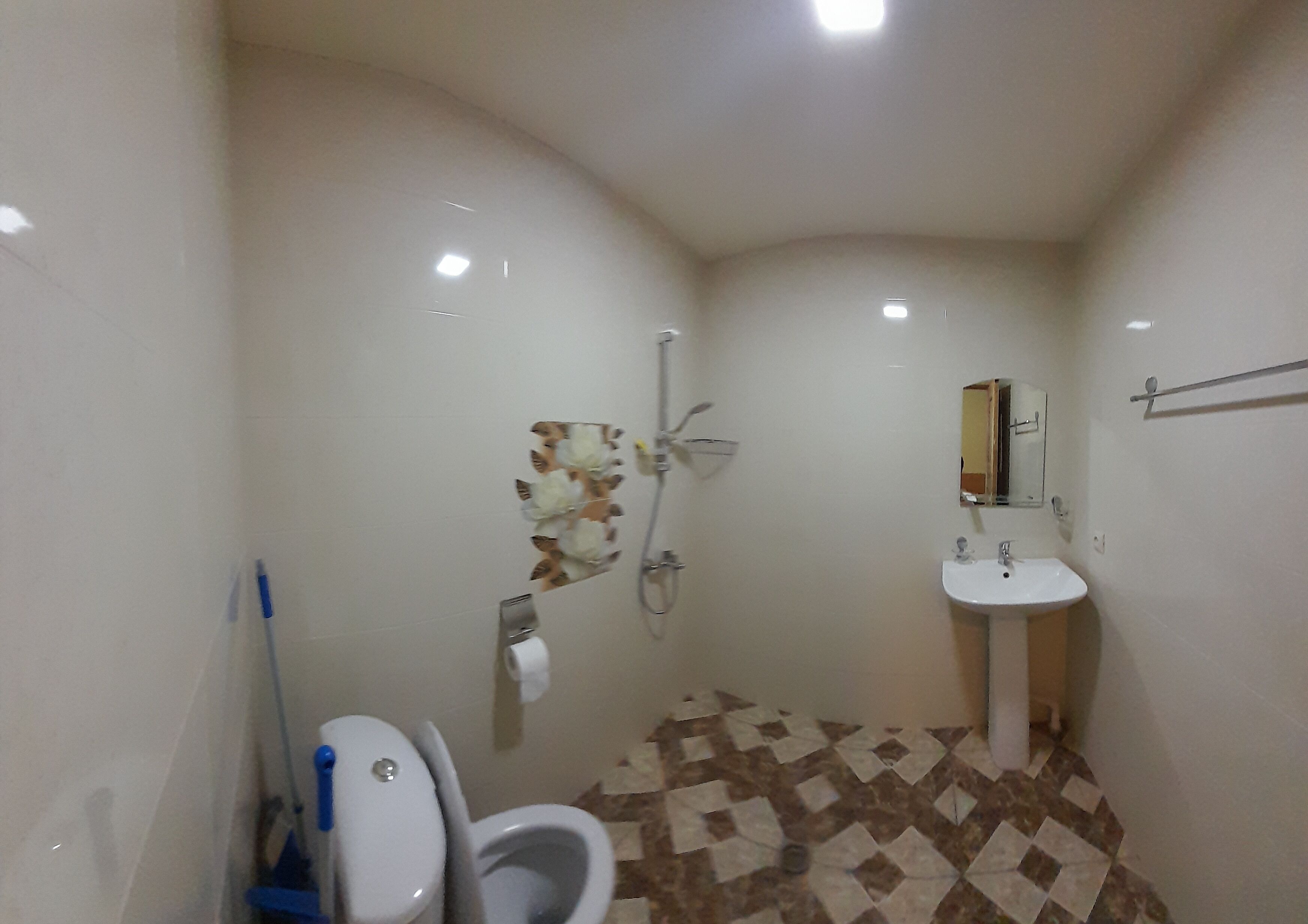 A small bathroom with a toilet, a shower, and a sink.