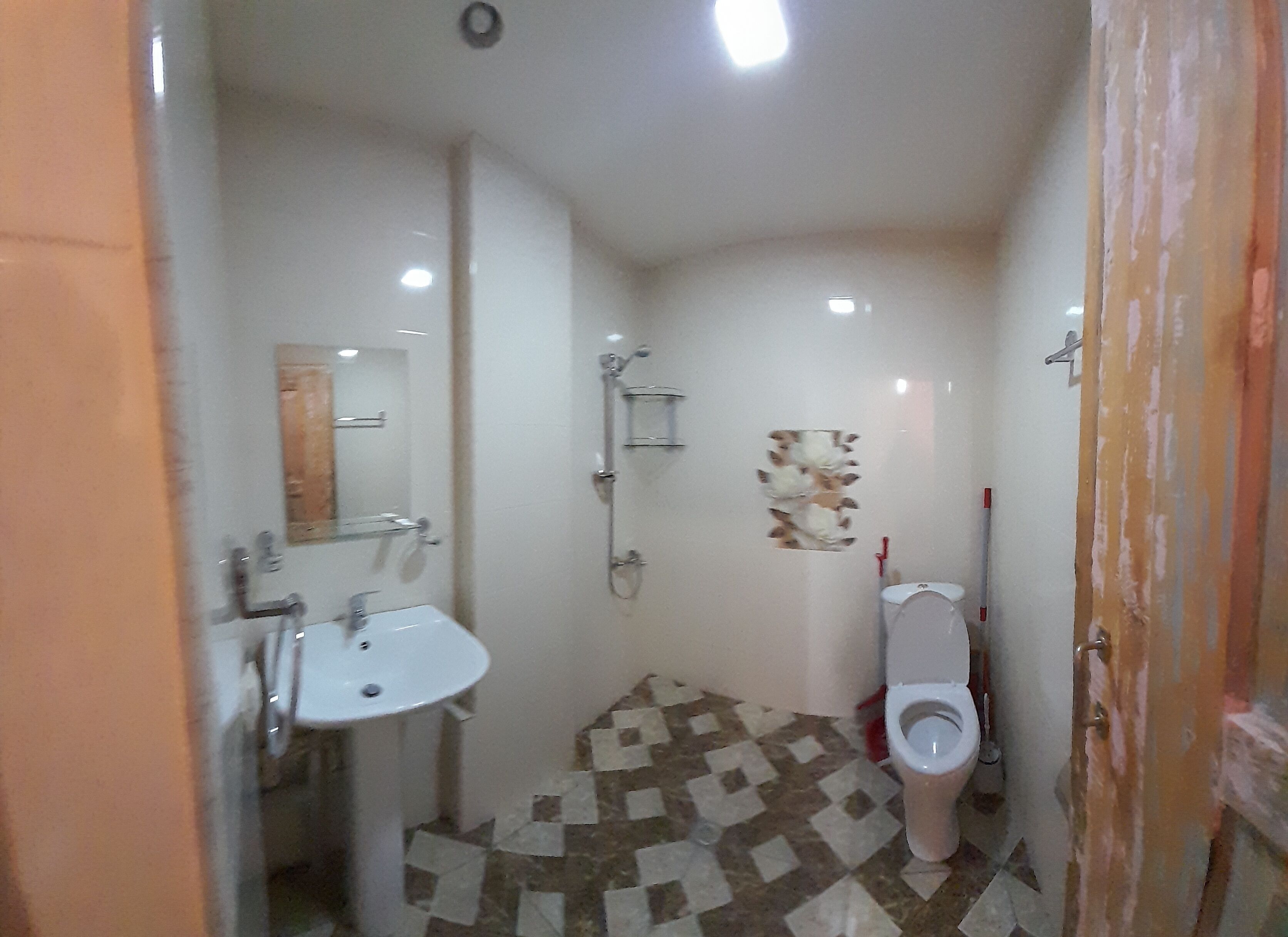 A small bathroom with a sink, toilet, and shower.