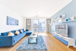 Appartement Deluxe | Coin séjour | TV connectée de 55 pouces avec chaînes par câble, télévision