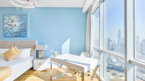 Een moderne slaapkamer met uitzicht over de stad, een wit bureau en een groot raam.