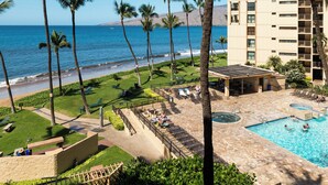 Ein Resort mit Pool, Palmen und Meerblick.