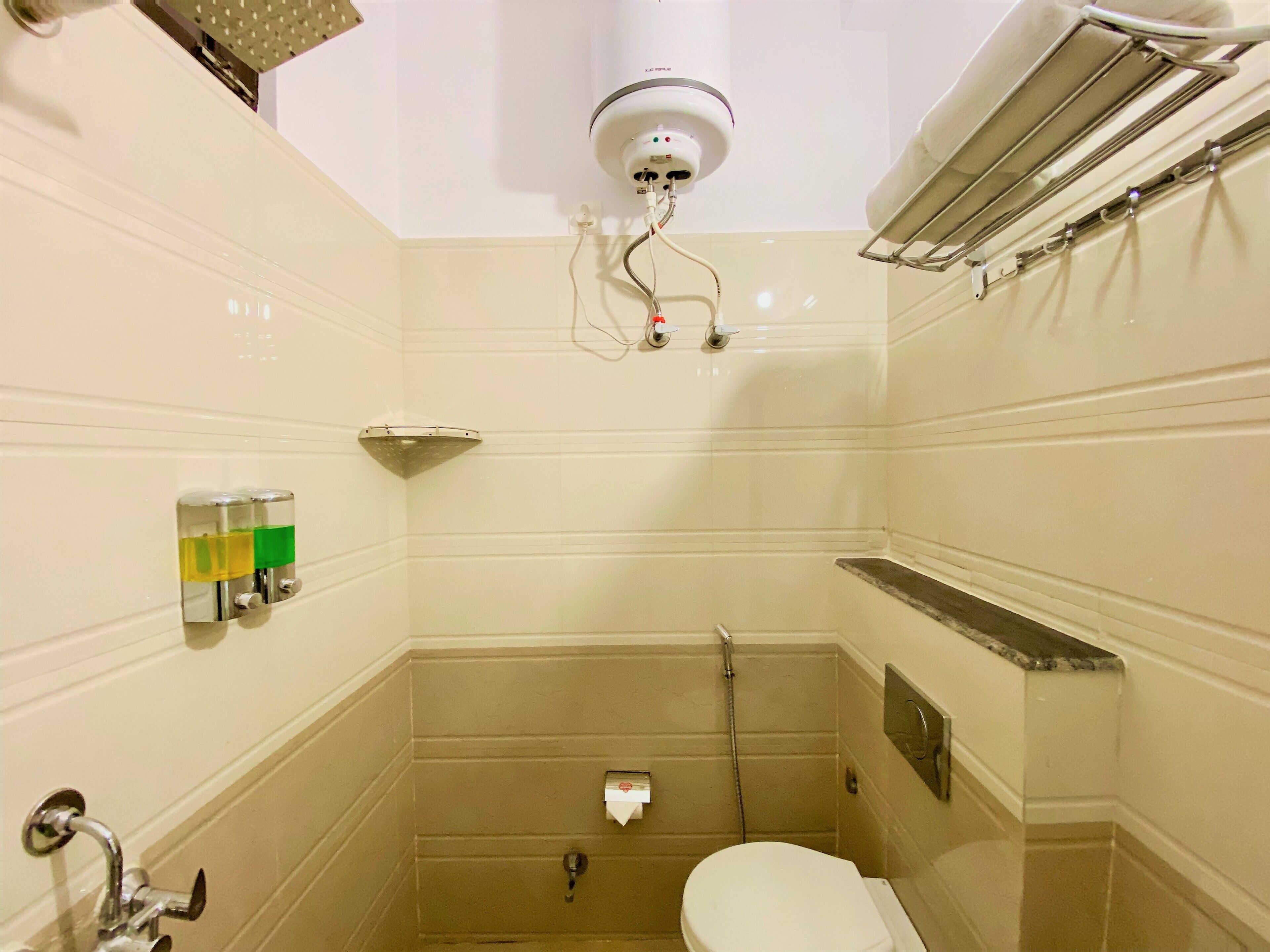 A small bathroom with a toilet, a shower, and a towel rack.