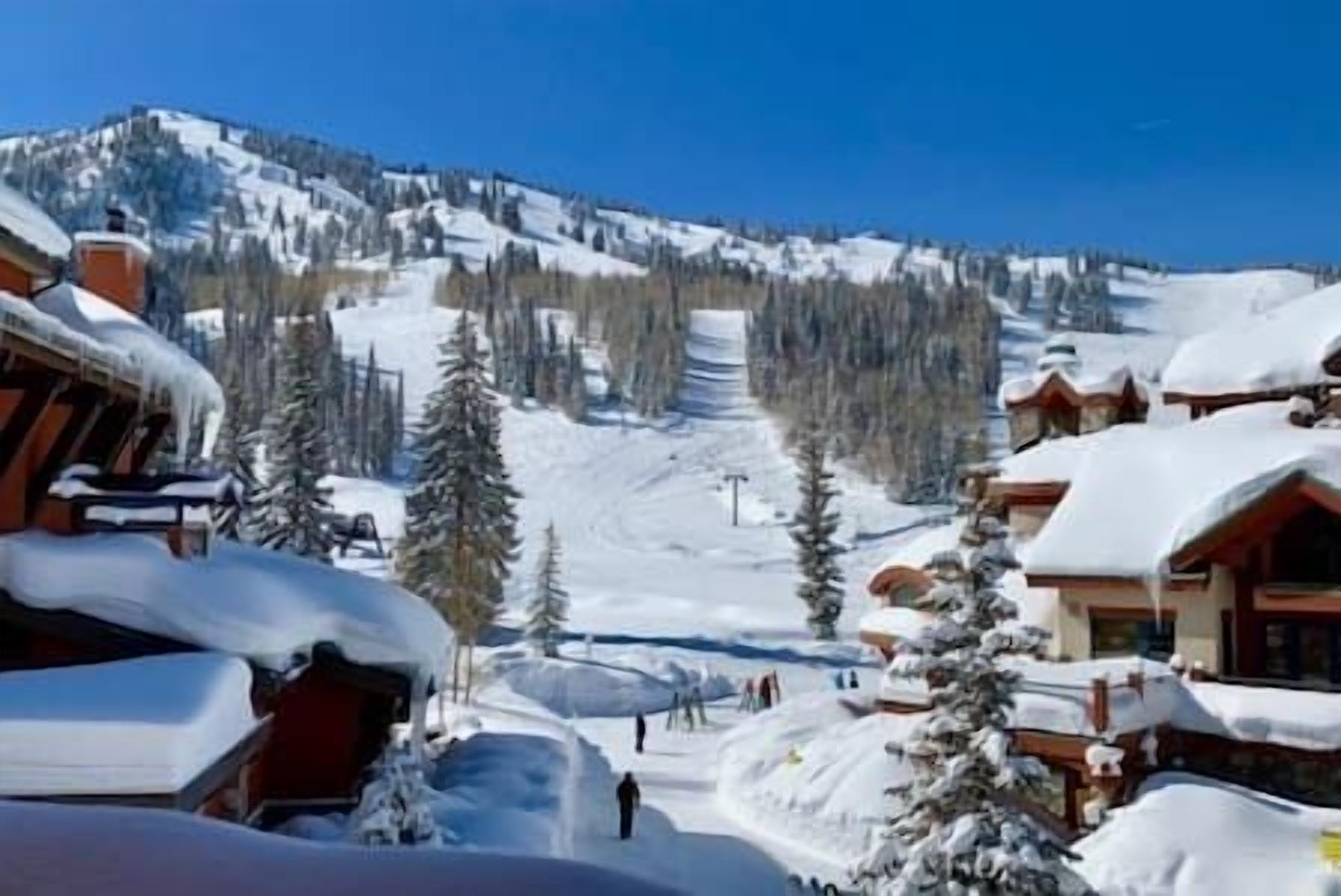A snowy mountain resort with cabins and a ski slope.