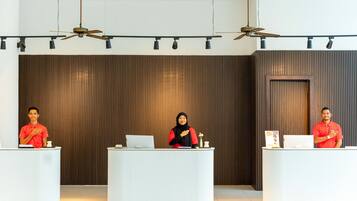 Three reception desks in a modern lobby with ceiling fans and recessed lighting.