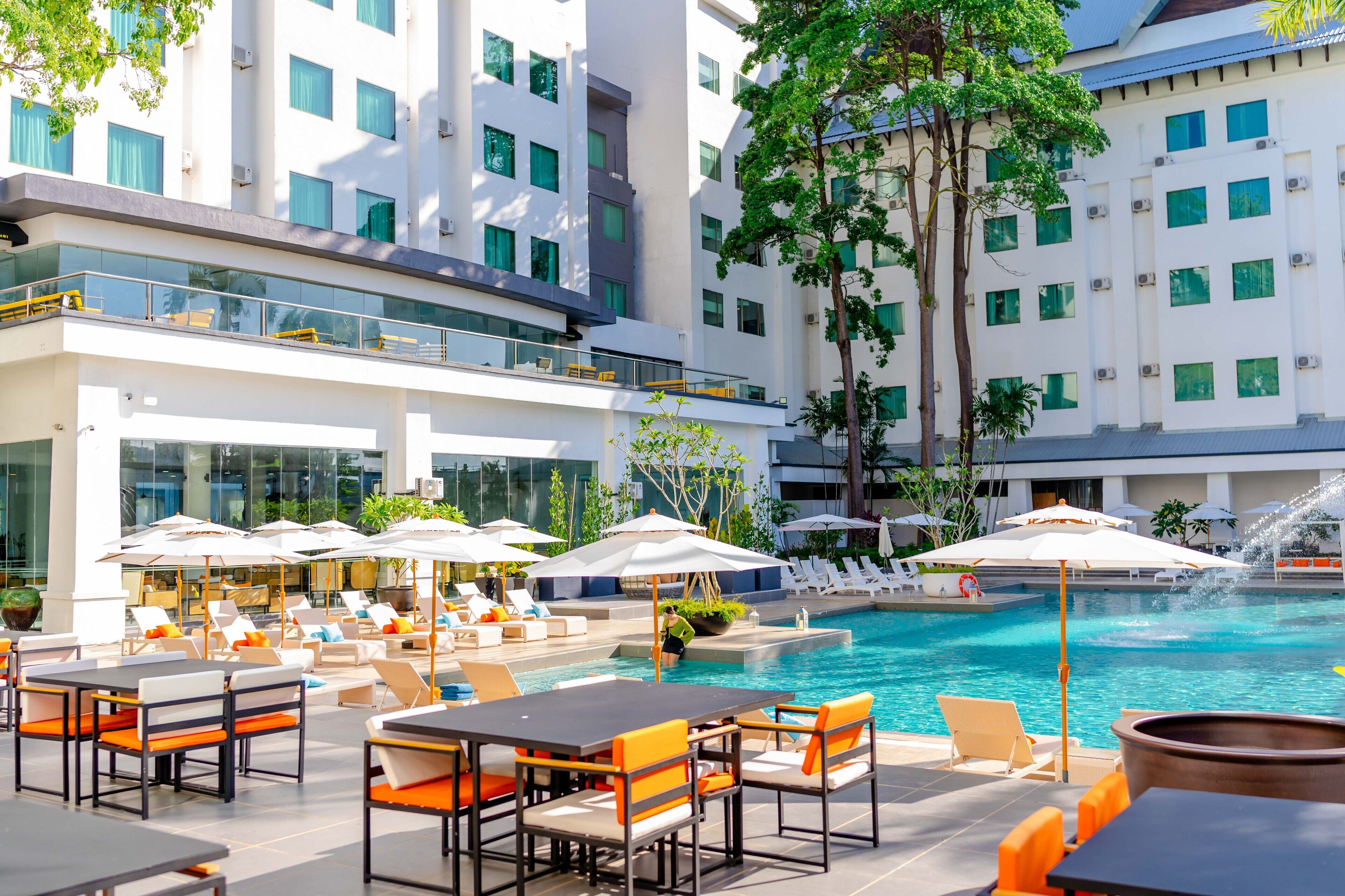 A poolside area with outdoor seating and a view of the pool.