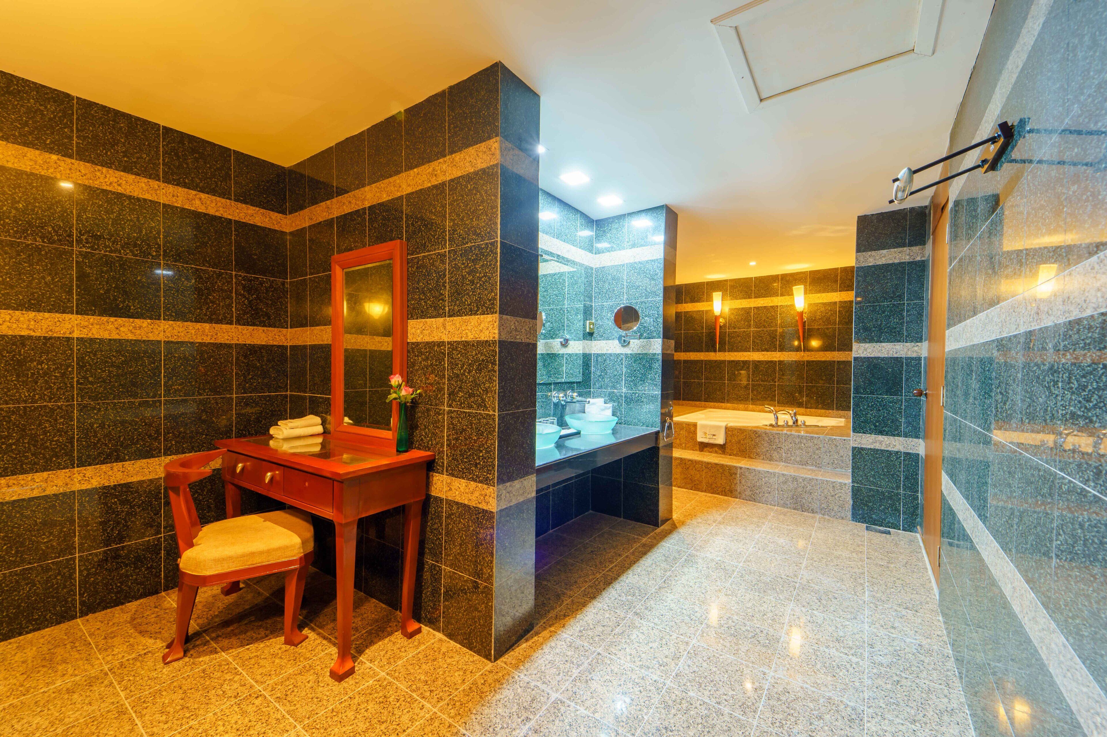 A modern bathroom with a marble floor, a wooden vanity with a mirror, and a glass-enclosed shower area.