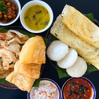 Ett urval av rätter från södra Indien, inklusive idli, dosa och kycklingcurry.