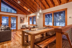 Enjoy a warm and inviting space with a dining table, sofa, and chair, offering a view of the surrounding landscape.