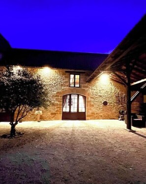 Traditional architecture meets natural charm at this rustic building with an arched entrance and tree-lined surroundings.