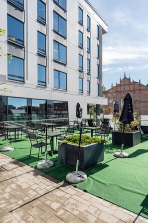A rooftop terrace with outdoor seating and planters.